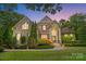 Elegant home exterior showcasing manicured landscaping, a grand entrance, and inviting curb appeal at twilight at 6795 Montgomery Rd, Lake Wylie, SC 29710