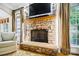 A stone fireplace with a wooden mantle creates a cozy focal point in the living room with hardwood floors at 6795 Montgomery Rd, Lake Wylie, SC 29710