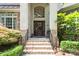 Charming front entrance with a wooden door, brick steps, and decorative wreath. The house has beautiful landscaping at 6795 Montgomery Rd, Lake Wylie, SC 29710