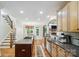 Open kitchen layout with hardwood floors, an island cooktop, and a seamless transition to dining area at 6795 Montgomery Rd, Lake Wylie, SC 29710