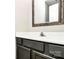 Bathroom vanity with a white sink, dark cabinets, and a decorative mirror at 7123 Meeting St, Charlotte, NC 28210