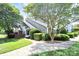Beautifully landscaped front yard with mature trees and shrubs framing the townhouse at 7123 Meeting St, Charlotte, NC 28210