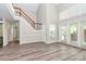 The open-concept living room features a staircase and a door to a patio for a blend of function and style at 7123 Meeting St, Charlotte, NC 28210