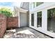 A cozy patio area with brick wall and white framed glass doors adds a touch of charm to this inviting home at 7123 Meeting St, Charlotte, NC 28210