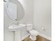Cozy powder room features a pedestal sink, round mirror and modern fixtures at 7160 Sumters Camp Trl, Indian Land, SC 29707