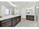 Bright bathroom features dual vanities with white quartz countertops, dark wood cabinets and tile flooring at 7160 Sumters Camp Trl, Indian Land, SC 29707