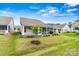 View of the home's back exterior with a screened porch, patio, and landscaped backyard at 7362 Overjoyed Xing, Charlotte, NC 28215