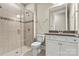 Well-lit bathroom featuring a walk-in shower, toilet, and vanity with tile floors at 7362 Overjoyed Xing, Charlotte, NC 28215
