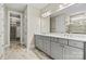 Gorgeous bathroom featuring gray cabinets, double vanity, tile floors, and a stunning tiled shower with glass door at 7362 Overjoyed Xing, Charlotte, NC 28215