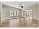 Spacious living room with hardwood flooring, a ceiling fan, and large windows for ample natural light at 7362 Overjoyed Xing, Charlotte, NC 28215