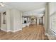 Open concept living area with wood floors, plentiful windows, and kitchen access at 7362 Overjoyed Xing, Charlotte, NC 28215
