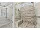 Close-up of beautiful walk-in shower with stone-look tile, glass door, and convenient bench at 7362 Overjoyed Xing, Charlotte, NC 28215