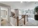 Bright hallway with wood-trimmed staircase and decorative leaf accent that leads into a living area with large windows at 7513 Lancaster Hwy # 6, Waxhaw, NC 28173