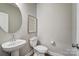 Cozy powder room with a pedestal sink, round mirror, and modern fixtures at 7513 Lancaster Hwy # 6, Waxhaw, NC 28173