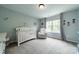 Cozy Bedroom featuring a white crib, comfy chair, and natural light from the window at 7650 W Berkeley Rd, Denver, NC 28037