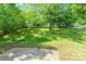 Spacious backyard with a patio area surrounded by mature trees and greenery at 8339 Hornwood Ct, Charlotte, NC 28215