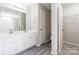 Bright bathroom featuring modern dual sinks, a walk-in closet, and a separate toilet at 8339 Hornwood Ct, Charlotte, NC 28215