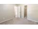 This bedroom features neutral walls and carpet with access to the hall and closet at 8339 Hornwood Ct, Charlotte, NC 28215