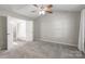 This bedroom has neutral walls and carpet with a ceiling fan, and attached bathroom at 8339 Hornwood Ct, Charlotte, NC 28215