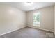 This bedroom features neutral paint, carpet, and a window for natural lighting at 8339 Hornwood Ct, Charlotte, NC 28215