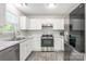 Bright kitchen featuring white cabinets, stainless steel appliances, and marble countertops at 8339 Hornwood Ct, Charlotte, NC 28215
