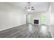 Bright living room with vaulted ceiling, ceiling fan, fireplace and wood-look floors at 8339 Hornwood Ct, Charlotte, NC 28215