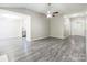 Open-concept floor plan with view into living room and kitchen with grey wood floors and neutral walls at 8339 Hornwood Ct, Charlotte, NC 28215