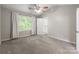 Bright main bedroom with ceiling fan, neutral walls, carpet, and large window at 8339 Hornwood Ct, Charlotte, NC 28215