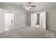 Light filled main bedroom with neutral walls, carpet, ceiling fan and view into main bath at 8339 Hornwood Ct, Charlotte, NC 28215