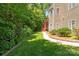 A well manicured backyard with green leafy trees, siding on home and painted stairs at 8914 Landsdowne Ave, Harrisburg, NC 28075