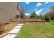 A backyard with a stone tiered wall and stairway with green grass and beautiful plants at 8914 Landsdowne Ave, Harrisburg, NC 28075