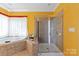 Bright bathroom with large soaking tub and tiled walk-in shower at 8914 Landsdowne Ave, Harrisburg, NC 28075