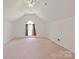 Spacious bonus room with plush carpet, ceiling fan, and a window allowing for natural light at 8914 Landsdowne Ave, Harrisburg, NC 28075