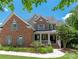 Charming brick two-story home with well-maintained landscaping and a welcoming front porch at 8914 Landsdowne Ave, Harrisburg, NC 28075