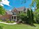 Landscaped front yard, well-manicured lawn and mature trees surrounding this beautiful brick home at 8914 Landsdowne Ave, Harrisburg, NC 28075