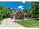Exterior of a two story brick home with a two car garage and long drive way at 8914 Landsdowne Ave, Harrisburg, NC 28075