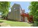 A view of the exterior of the home with siding and a red painted deck at 8914 Landsdowne Ave, Harrisburg, NC 28075