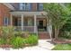 Close-up of the home's entry with a brick walkway, white porch columns, and garden beds at 8914 Landsdowne Ave, Harrisburg, NC 28075