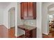 Hallway desk with granite counter, wooden floors and cabinets, and an arched doorway at 8914 Landsdowne Ave, Harrisburg, NC 28075
