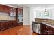 Kitchen area boasting dark wood cabinets, granite countertops, stainless steel appliances, and wood floors at 8914 Landsdowne Ave, Harrisburg, NC 28075