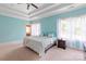 Serene main bedroom featuring a trey ceiling, calming blue walls, and light-filled windows with sheer white curtains at 8914 Landsdowne Ave, Harrisburg, NC 28075