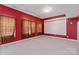 Versatile recreation room with red walls, a projector screen, and cozy patterned curtains at 8914 Landsdowne Ave, Harrisburg, NC 28075