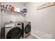 Efficient laundry room with modern washer and dryer, complemented by convenient shelving for storage at 9034 Evercrisp Ln, Charlotte, NC 28215