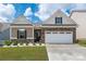 Charming home featuring manicured landscaping, a stone facade, and a two-car garage on a sunny day at 9034 Evercrisp Ln, Charlotte, NC 28215