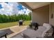 Covered outdoor patio featuring a comfortable seating area, grill, and views of the expansive backyard at 9034 Evercrisp Ln, Charlotte, NC 28215