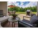 Outdoor patio features seating, a grill, and a view of the green backyard against a backdrop of trees at 9034 Evercrisp Ln, Charlotte, NC 28215