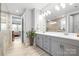 Modern bathroom with dual vanity, large mirror, gray cabinets, and tiled floors at 9109 Liberty Hill Dr, Mint Hill, NC 28227