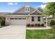 Charming single-story home featuring a brick facade, attached garage, and well-maintained landscaping at 9109 Liberty Hill Dr, Mint Hill, NC 28227