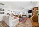 Open-concept living room with fireplace, ceiling fan, wood floors, and modern furnishings at 9109 Liberty Hill Dr, Mint Hill, NC 28227