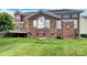 Brick house backyard with a large, arched window and a well-maintained green lawn at 1000 Sarandon Dr, Matthews, NC 28104